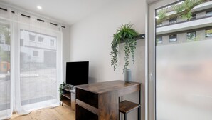 Una sala de estar moderna con una mesa de centro de madera, un televisor y una planta colgante.