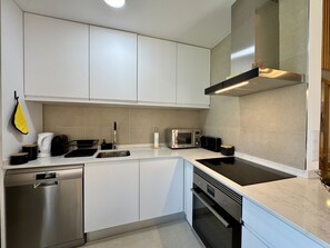 A modern kitchen with stainless steel appliances, a dishwasher, and a built-in oven. - Vilamoura Marina View 3 by Homing (Loulé)