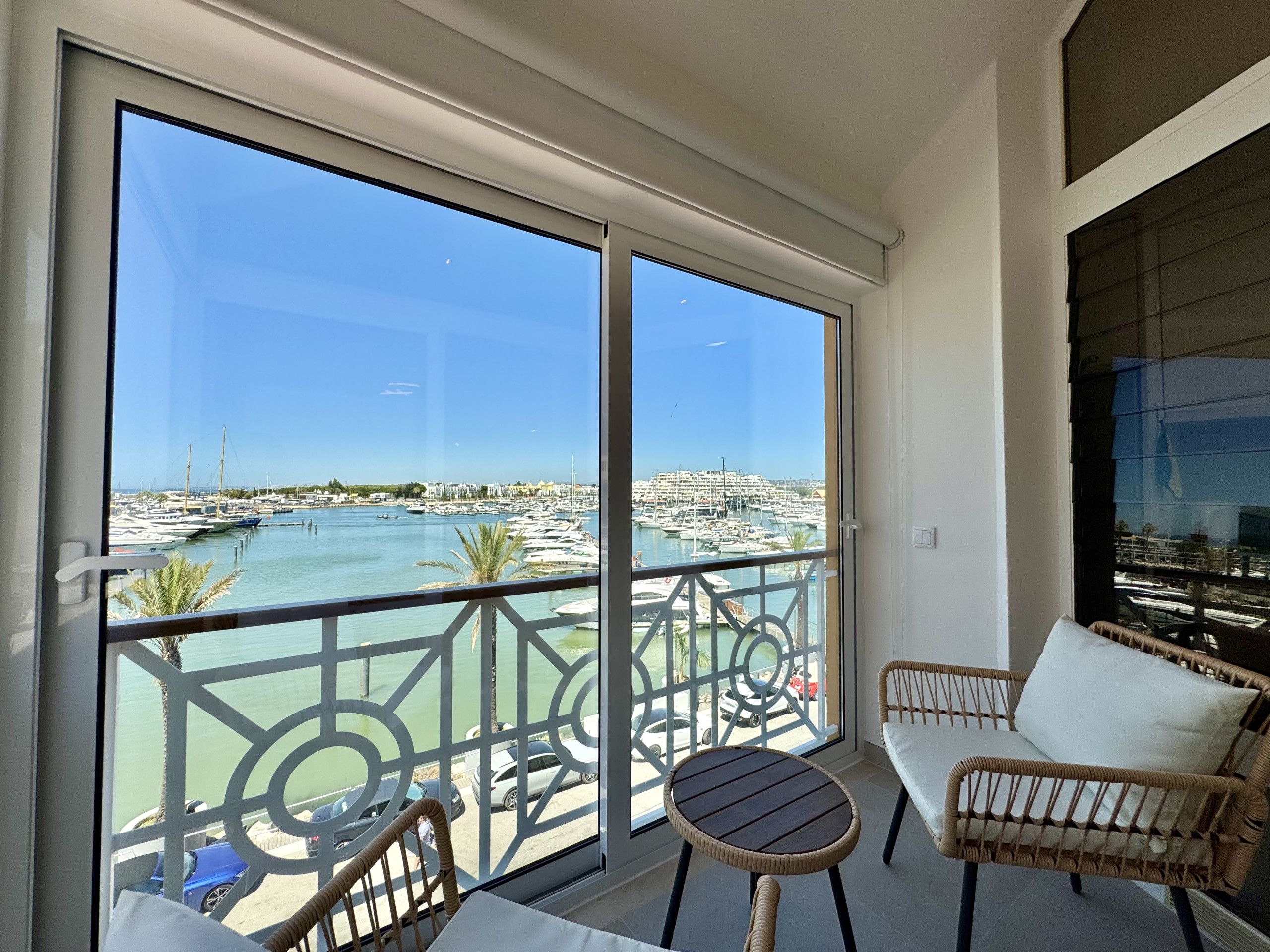 Un balcon avec vue sur un port de plaisance et sur le paysage urbain.