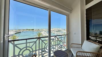Un balcon avec vue sur un port de plaisance et sur le paysage urbain.