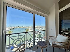 Un balcon avec vue sur un port de plaisance et sur le paysage urbain.