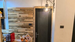 A kitchen with a wooden countertop, a red toaster, and a door with a textured panel. - Cozy apartment in the Umbrian countryside, small animals welcome! (I Prati)