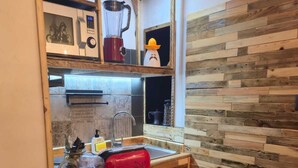 A kitchen with a wooden countertop, a red suitcase, and various food items. - Cozy apartment in the Umbrian countryside, small animals welcome! (I Prati)