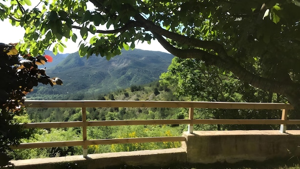 Un banco de madera con vista a un paisaje montañoso.