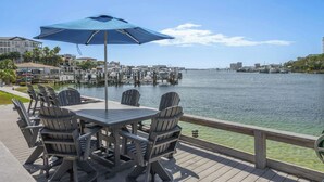 A waterfront deck with outdoor seating and a view of the marina. - Destin Retreat: Walk to Private Beach & Pool (Destin)