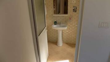 Een douche, handdoeken, zeep, toiletpapier