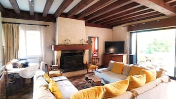 Télévision, cheminée, table de tennis de table, livres