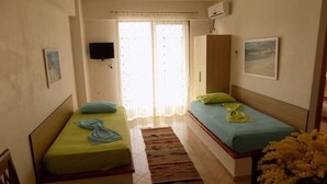 A bedroom with two beds, a television, a window with curtains, and a painting on the wall. - 25 meters from beach 1 (Himarë)