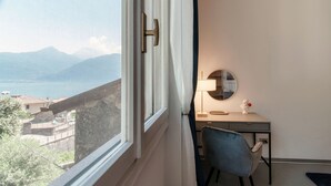 Una habitación con escritorio, silla y vistas a un paisaje montañoso a través de una ventana.