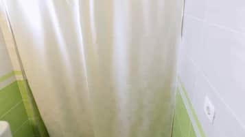 Een douche, handdoeken, zeep, toiletpapier