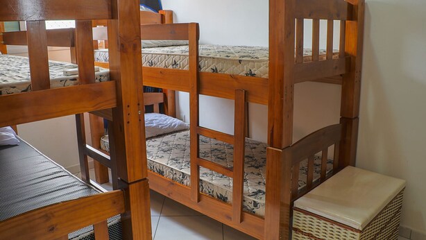 Un lit superposé avec une structure en bois et un matelas à motifs floraux.