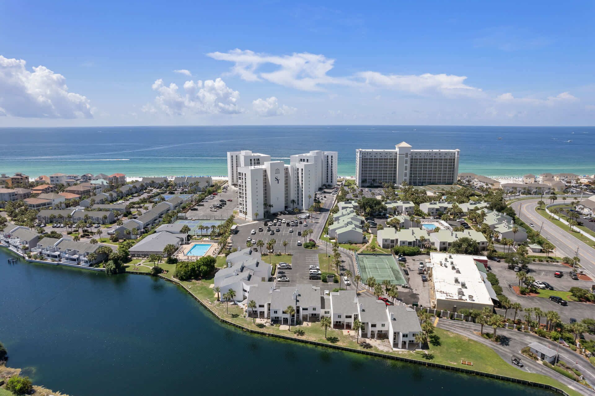 A coastal hotel area with multiple buildings, a marina, and a view of the ocean.