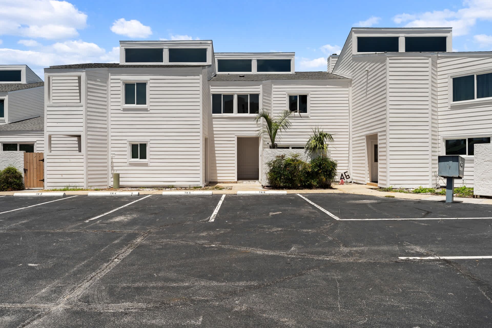 Um edifício residencial de vários andares com estacionamento na frente.