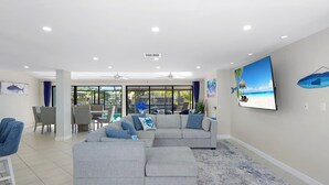 A modern living room with a sectional sofa, dining area, and large windows.