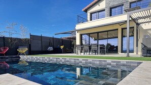 A modern house with a swimming pool, outdoor seating, and a covered patio area. - Maison du lac, 1h from Lyon and Genèves, Jacuzzy, swimming pools, magnificent lake view. (Jayat)