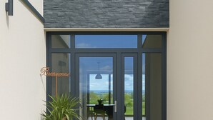 A modern entrance with a glass door, a potted plant, and a statue. - Maison du lac, 1h from Lyon and Genèves, Jacuzzy, swimming pools, magnificent lake view. (Jayat)