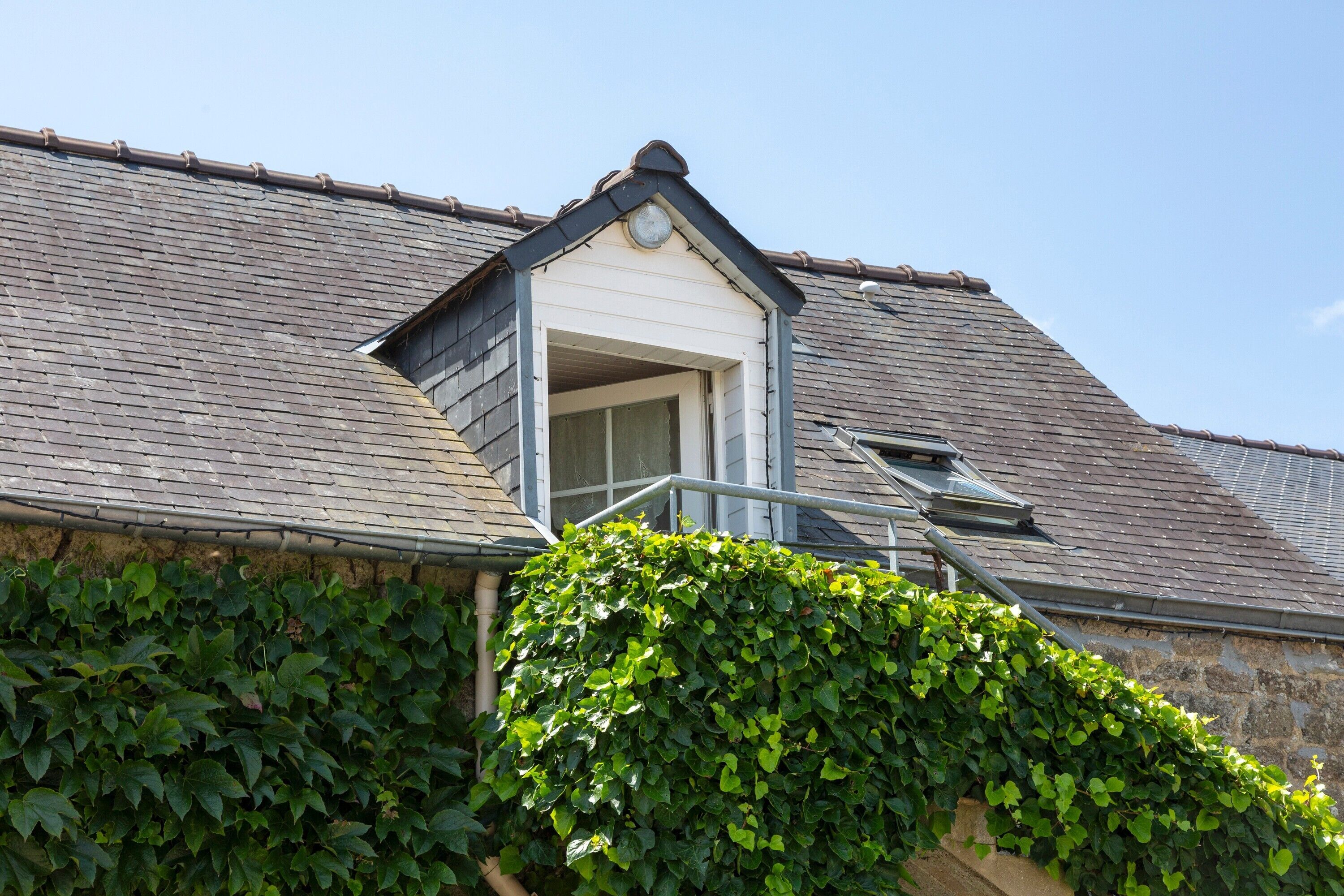 A building with a sloped roof, a small window, and a door.