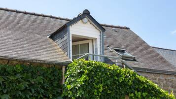 A building with a sloped roof, a small window, and a door.