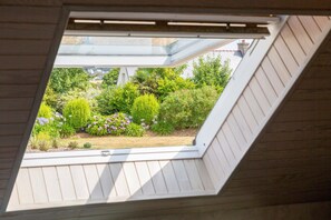 Une lucarne donnant sur un jardin.