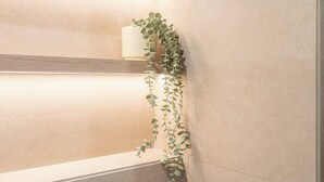 A bathroom with a towel rack, a plant, and a light fixture. - StayShort - Town Square Stylish Studio for 2 people! (Town Square)