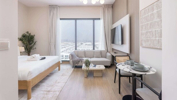 A modern hotel room with a bed, a sofa, a dining table, and a large window offering a city view. - StayShort - Town Square Stylish Studio for 2 people! (Town Square)