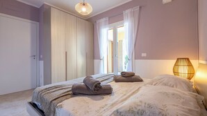A bedroom with a bed, a bedside lamp, and a wardrobe.