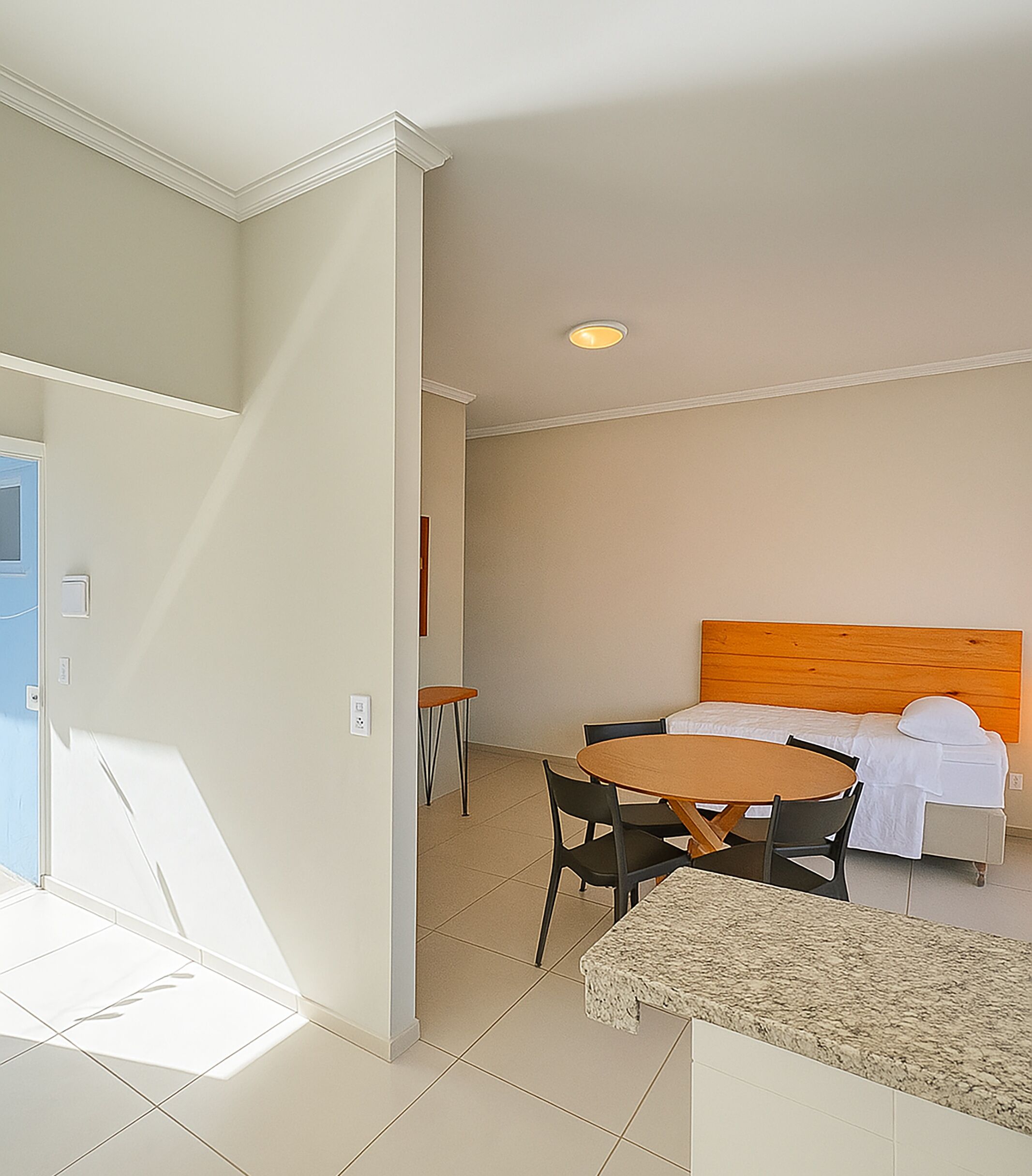 A hotel room with a bed, a round table, and chairs.
