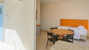A hotel room with a bed, a round table, and chairs.
