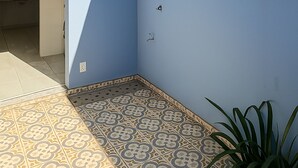 A bathroom with a blue wall, a shower, and patterned floor tiles. - Villa Brotas (Brotas)