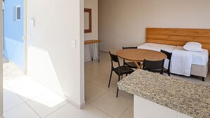 A hotel room with a bed, a small table, chairs, and a bathroom visible through an open door. - Villa Brotas (Brotas)