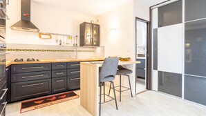 Una cocina moderna con armarios negros, encimera de madera, estufa integrada y campana extractora negra.