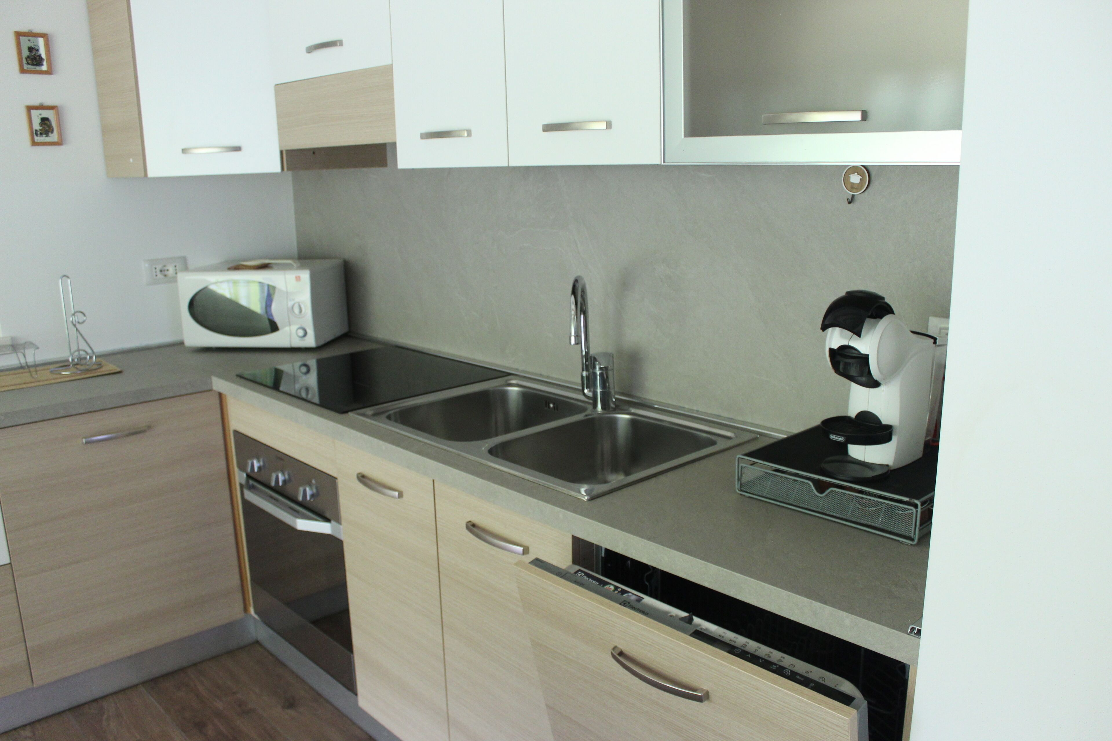 A modern kitchen with stainless steel appliances, a microwave, a coffee machine, and a dishwasher.
