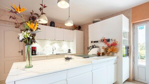 Una cocina moderna con armarios blancos, encimera de mármol y una isla grande.