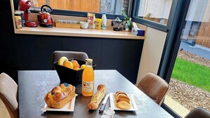 Una mesa de desayuno servida con croissants, jugo de naranja y café.