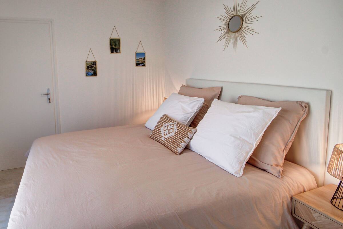 Ein Schlafzimmer mit Bett, Nachttisch und Schreibtisch mit Stuhl.