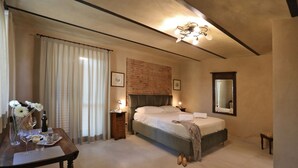Ein Hotelzimmer mit einem Bett, einem Nachttisch mit Lampe, einem Spiegel und einem Fenster mit Vorhängen.