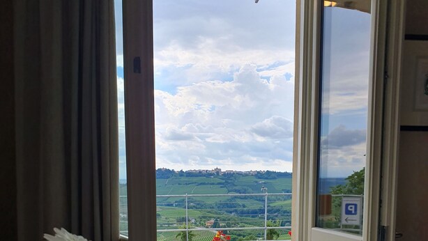 Ein Zimmer mit Blick auf eine grüne Landschaft durch eine offene Tür.