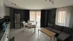 A compact living space with a kitchenette, dining area, and seating area.