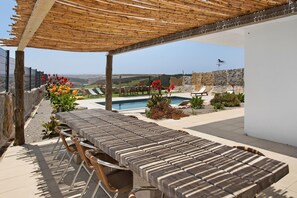 An outdoor patio with a pool, lounge chairs, and a view of the landscape. - Room 'Mars' with Mountain View, Shared Pool and Wi-Fi Access (Lourinhã)