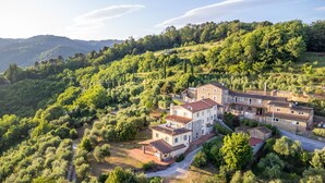 A large, multi-story stone building with a courtyard, surrounded by lush greenery and hills. - Smart Panoramic Farmhouse Jacuzzi in Montecatini Alto (Montecatini alto)