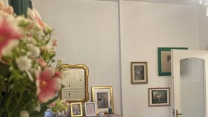 Una habitación con un aparador de madera, un mantel de encaje y una puerta con panel de vidrio.
