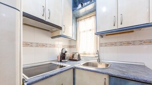 A compact kitchen with a gas stove, a toaster, and a sink. - Bright Apartment 'Zapillomotril' with Air Conditioning (Almería)