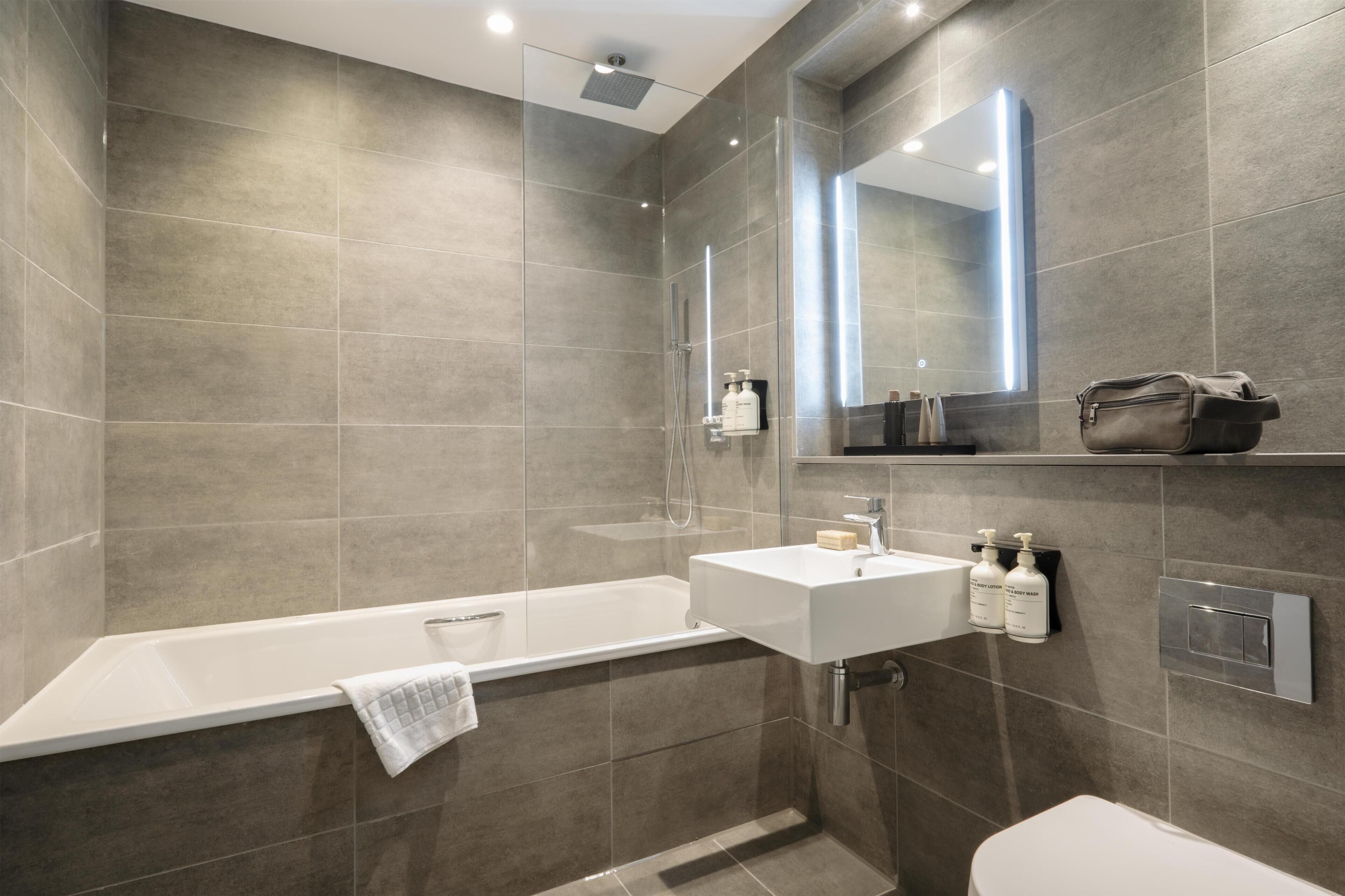 Un baño moderno con bañera, lavamanos e inodoro.