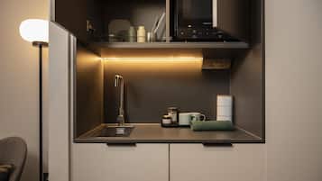 A compact kitchenette with a built-in microwave, a sink, and a small countertop area.