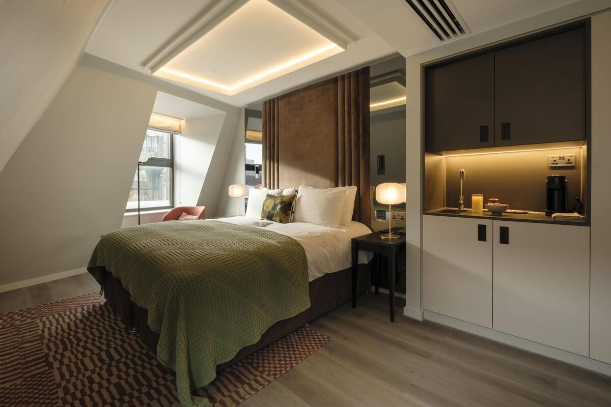 Un dormitorio moderno con cama, mesita de noche y armario empotrado.