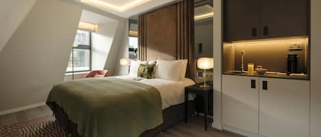 A modern bedroom with a bed, bedside table, and a built-in wardrobe.