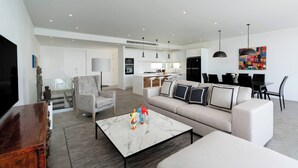 A modern living room with a sofa, a coffee table, and a TV.