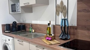 A modern kitchen with a built-in microwave, a coffee maker, a toaster, and a sink.