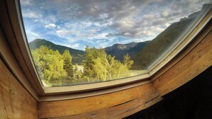 Ein Oberlicht mit Blick auf eine gebirgige Landschaft und Bäume.