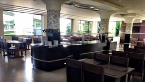 A spacious restaurant with high ceilings, large windows, and a central counter area. - Samambaia Hotel (Foz do Iguaçu)